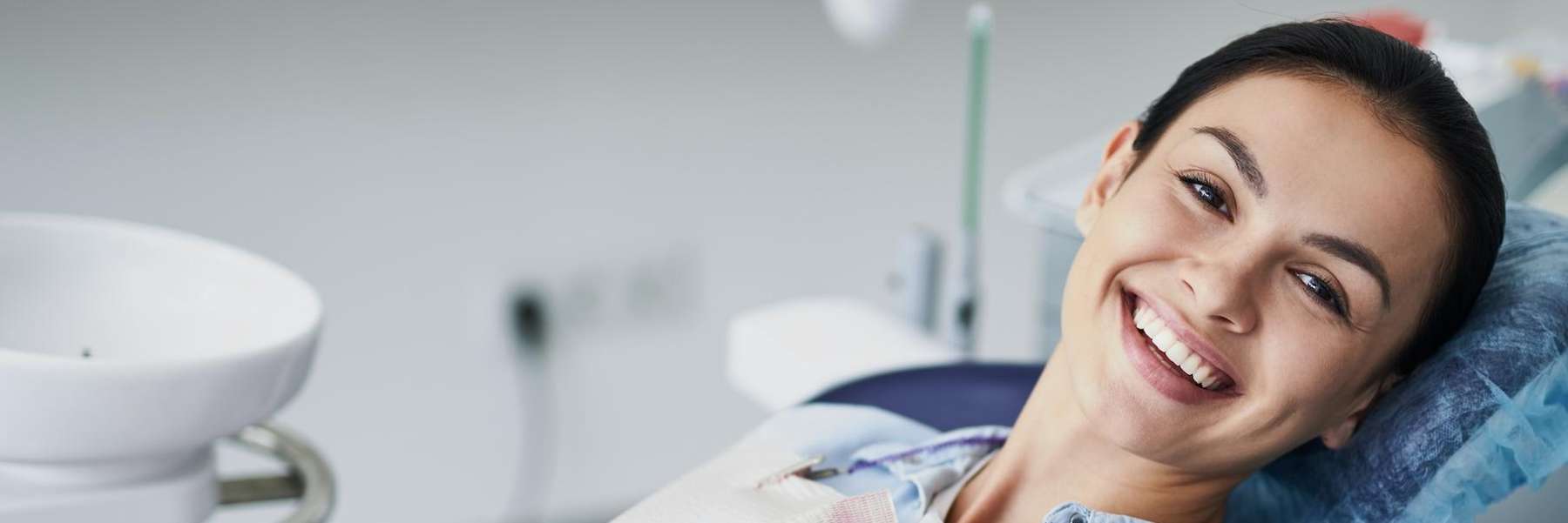 woman smiling in dentist exam chair | dentist in reservoir